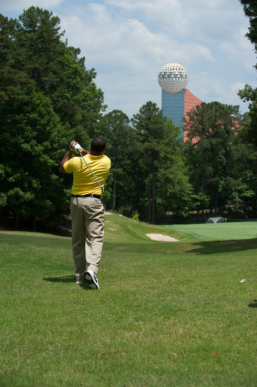 man golfing with casino backdrop